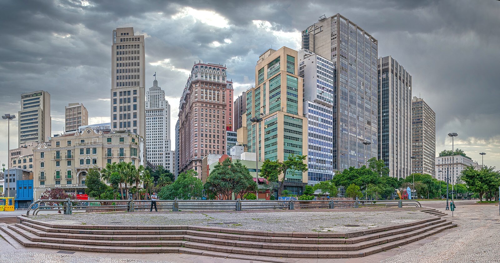 戏剧性天空下的 Vale do Anhangabaú 全景，画面可见 São Paulo 市中心建筑